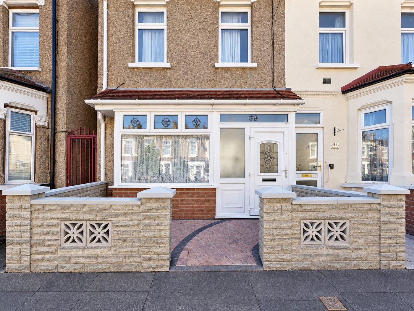 Refurbished house frontage with new front walls and a patterned block-paved path